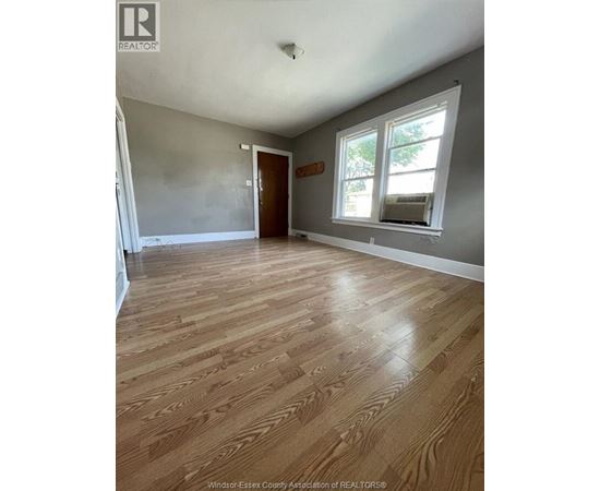 A room with wooden flooring and a window.