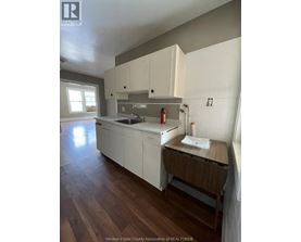 A kitchen with white cabinets and a wooden island.