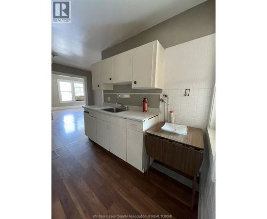 A kitchen with white cabinets and a wooden island.