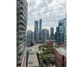 A cityscape with tall buildings and a cloudy sky.