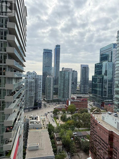 A cityscape with tall buildings and a cloudy sky.