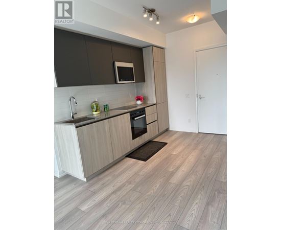 A modern kitchen with wooden cabinets and a white countertop.