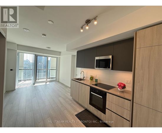 A modern kitchen with wooden cabinets and a black countertop.