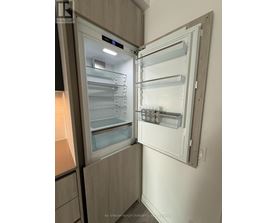 A modern kitchen with a refrigerator that has its door open.