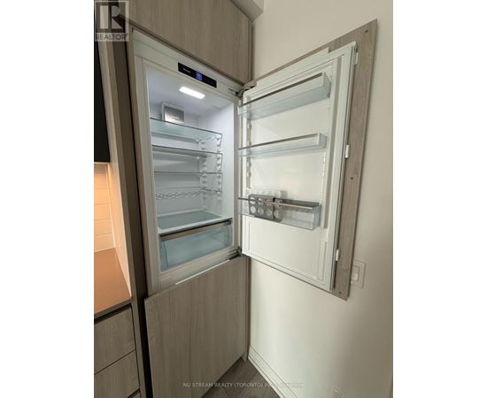 A modern kitchen with a refrigerator that has its door open.