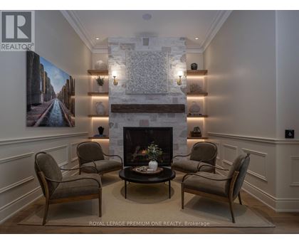A living room with a fireplace and a painting on the wall.