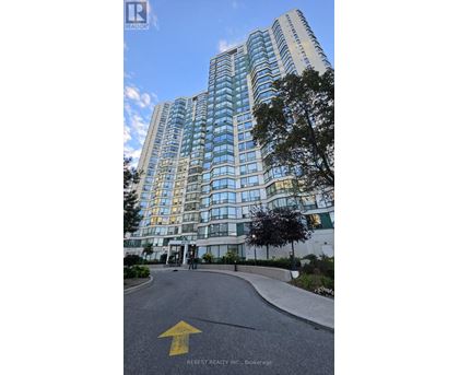 A tall building with many windows is shown with a yellow arrow on the road in front.