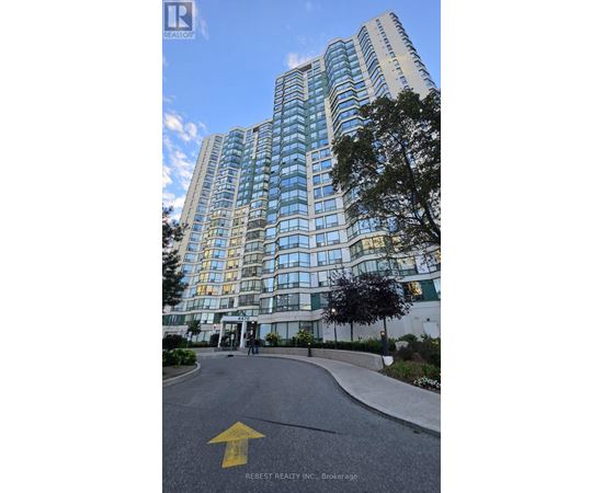 A tall building with many windows is shown with a yellow arrow on the road in front.