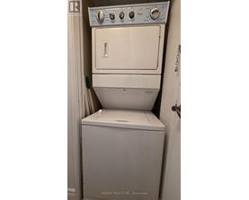 A white dryer and washer in a small room.