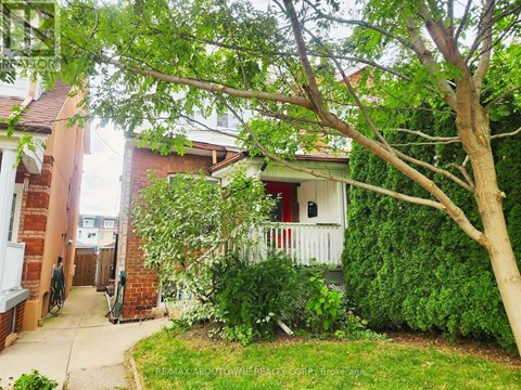 A tree is in front of a house.