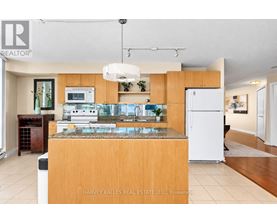 A kitchen with a granite countertop and a white refrigerator.