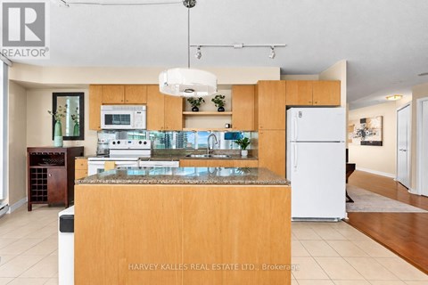 A kitchen with a granite countertop and a white refrigerator.