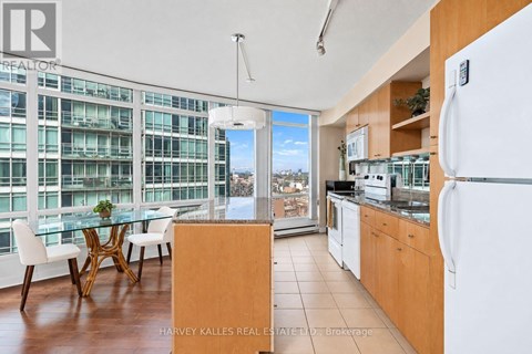 A kitchen with a table and chairs in front of a window with a view of a cityscape.