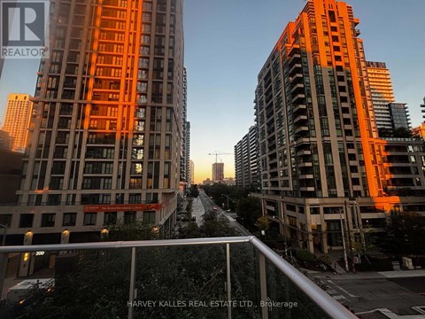 Two tall buildings with orange lighting and a street in between.
