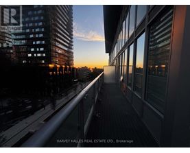 A balcony overlooks a city street at sunset.