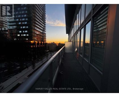 A balcony overlooks a city street at sunset.