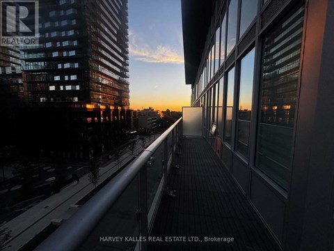 A balcony overlooks a city street at sunset.