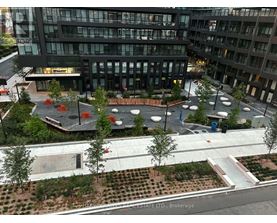 A view of a courtyard with a fountain and seating area in front of a building.