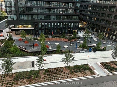 A view of a courtyard with a fountain and seating area in front of a building.