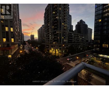 A cityscape at dusk with the sun setting behind the buildings.