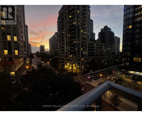 A cityscape at dusk with the sun setting behind the buildings.