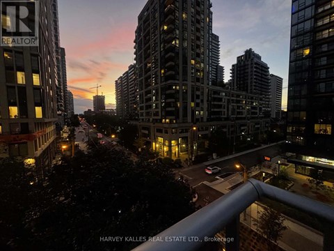 A cityscape at dusk with the sun setting behind the buildings.