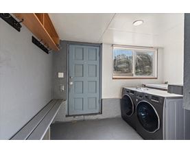 A laundry room with a washer and dryer and a blue door.