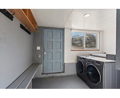 A laundry room with a washer and dryer and a blue door.