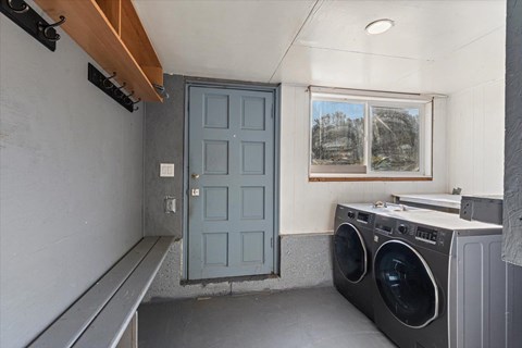 A laundry room with a washer and dryer and a blue door.