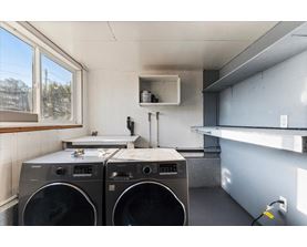 Two front loading washing machines in a laundry room.