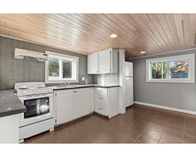 A kitchen with white appliances and cabinets.