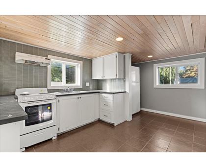 A kitchen with white appliances and cabinets.