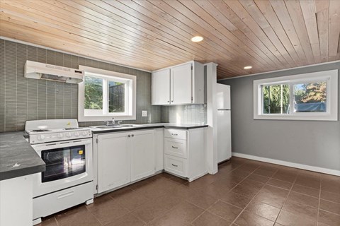 A kitchen with white appliances and cabinets.