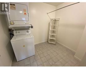 A white refrigerator in a room with a shelf.