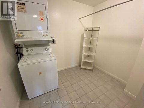 A white refrigerator in a room with a shelf.