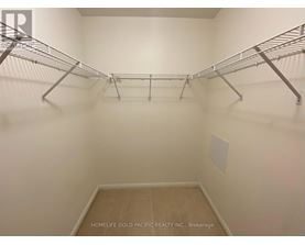 A walk-in closet with shelving and a wooden floor.