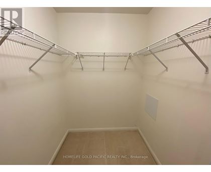 A walk-in closet with shelving and a wooden floor.