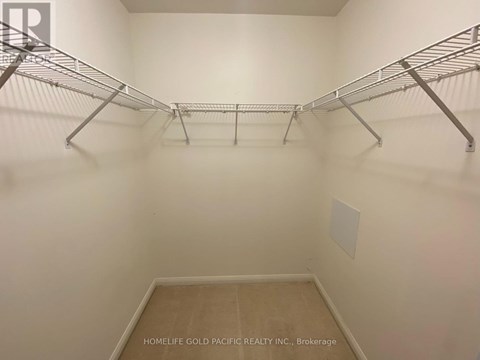 A walk-in closet with shelving and a wooden floor.