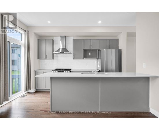A modern kitchen with a large island and stainless steel appliances.