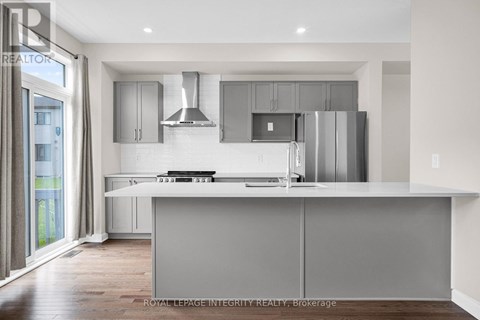 A modern kitchen with a large island and stainless steel appliances.