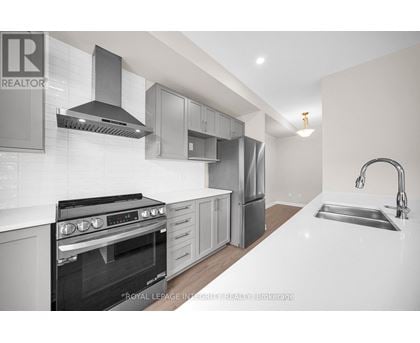 A modern kitchen with a stove top oven and a sink.