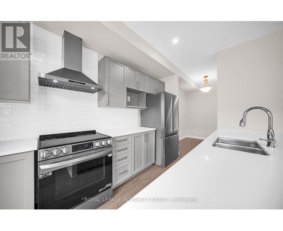 A modern kitchen with a stove top oven and a sink.