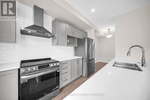 A modern kitchen with a stove top oven and a sink.