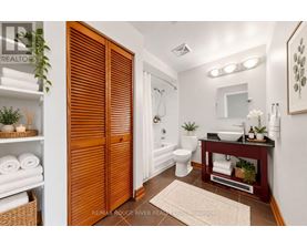 A bathroom with a toilet, sink, and a mirror.