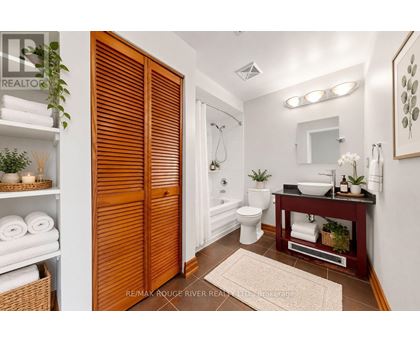 A bathroom with a toilet, sink, and a mirror.