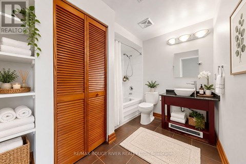 A bathroom with a toilet, sink, and a mirror.
