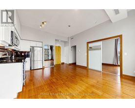 A spacious room with wooden floors and white walls.
