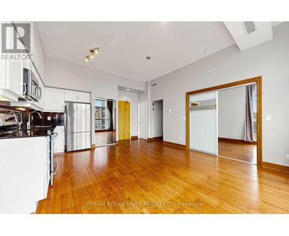 A spacious room with wooden floors and white walls.