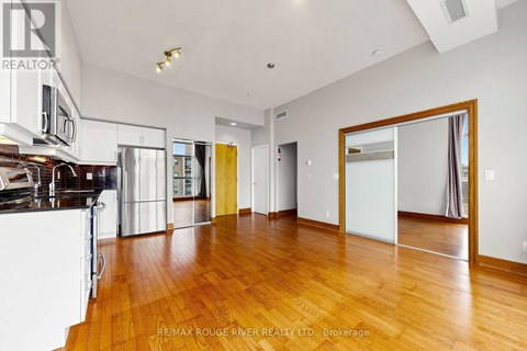 A spacious room with wooden floors and white walls.