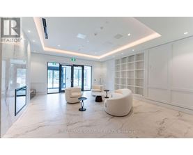 A spacious waiting area with white furniture and marble flooring.